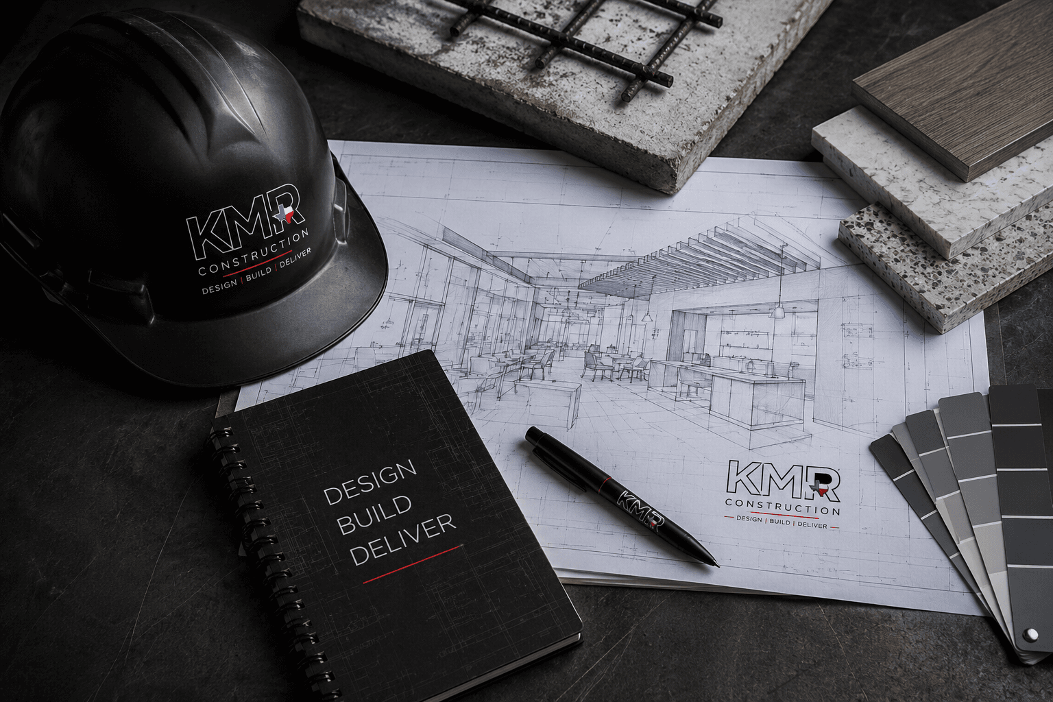 KMR Construction design-build flat lay with hard hat, interior rendering, finish samples, and Design • Build • Deliver notebook