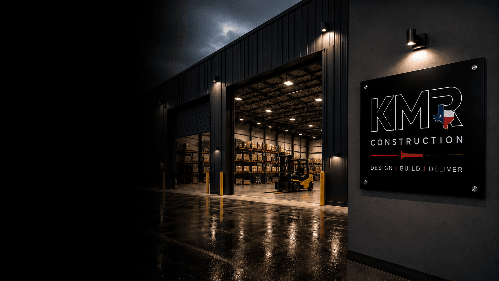 KMR-built industrial warehouse with open dock doors and KMR signage at twilight